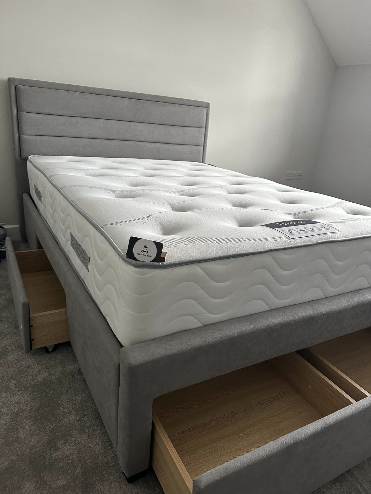 Thick mattress on top of grey material double bed