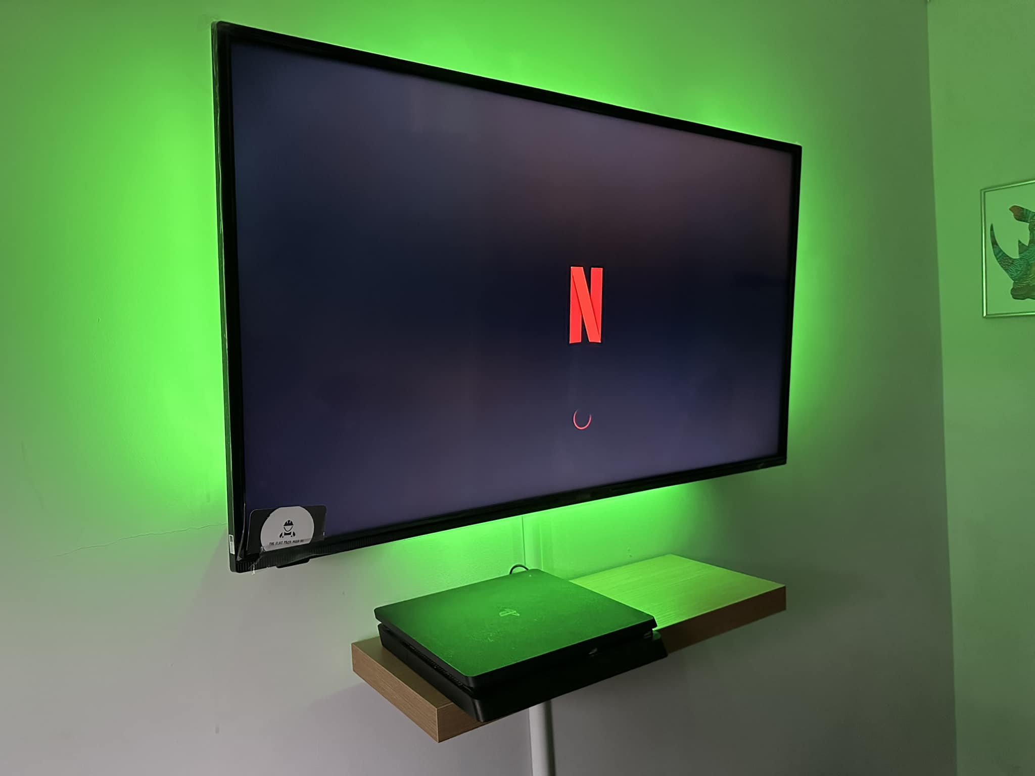 TV mounted on wall with green back light